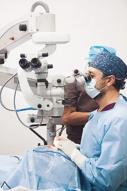 Cirujano oftalmólogo de OCUMED realizando procedimiento ocular con equipo de microscopía avanzada en quirófano especializado de Querétaro.