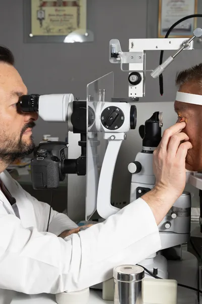 Oftalmologo en Ocumed evaluando cataratas con lampara de hendidura durante consulta especializada