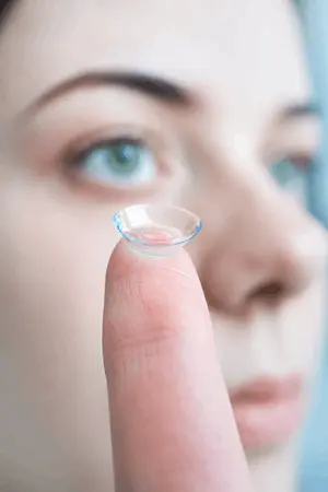 Persona sosteniendo un lente de contacto utilizado para la correccion visual del astigmatismo y otros errores refractivos bajo supervision oftalmologica