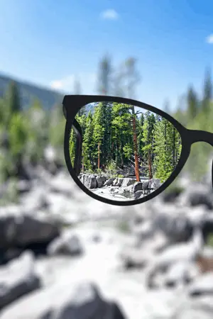 Lentes graduados mostrando una imagen nitida del paisaje mientras el entorno exterior permanece desenfocado para representar la correccion visual personalizada